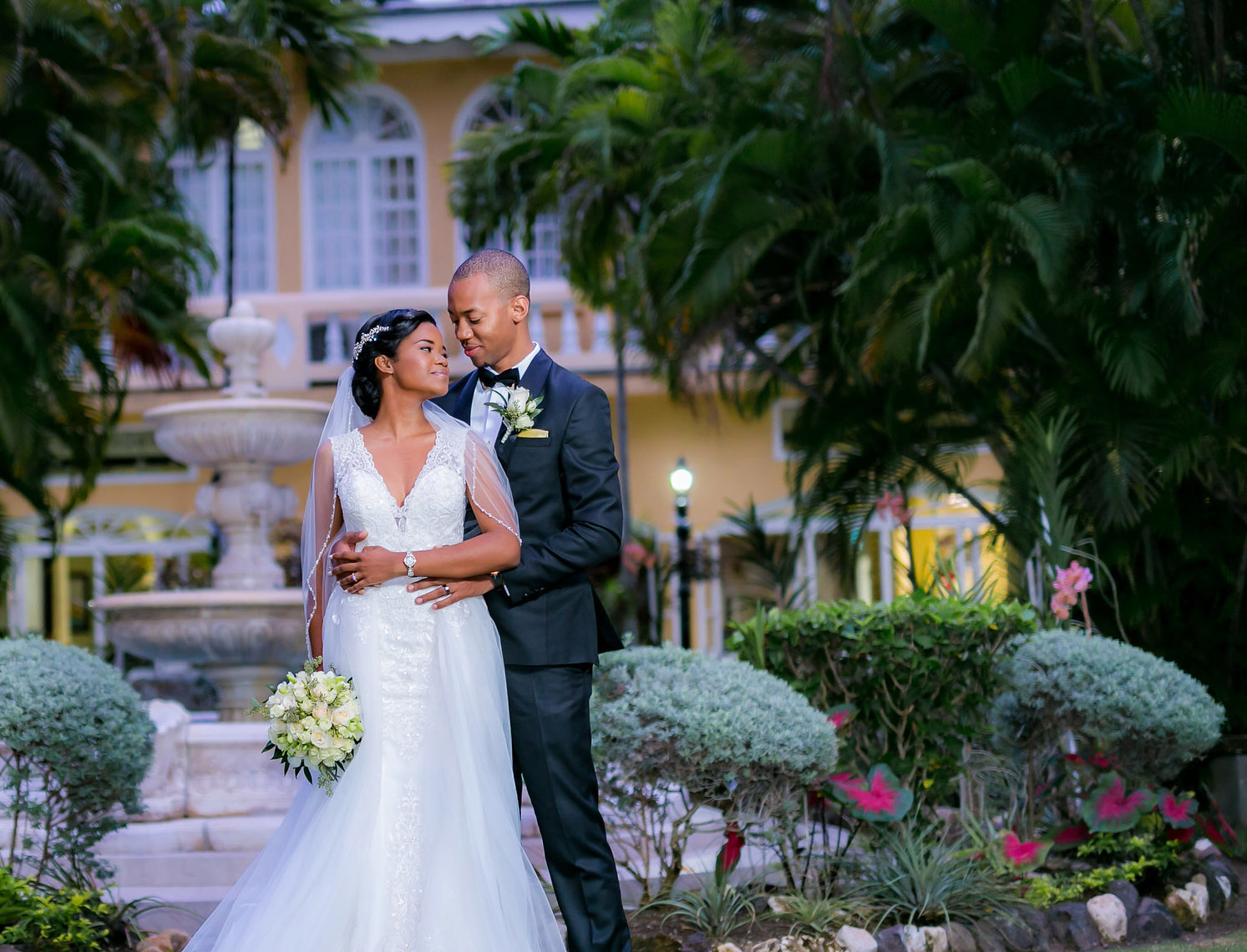 A newlywed couple beside the great house fountain